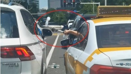 汉口街头发生不和谐一幕：白色汽车有人向出租车泼水，的哥挥舞甩棍击破白车玻璃……